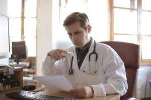 Médico analisando uma intimação de sindicância enviada pelo CRM - Image by wirestock on Freepik.com